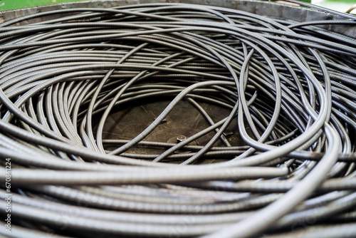 A coil of iron wire is shot close-up, a flexible spring in a long hose. Manufacture of metal products. photo
