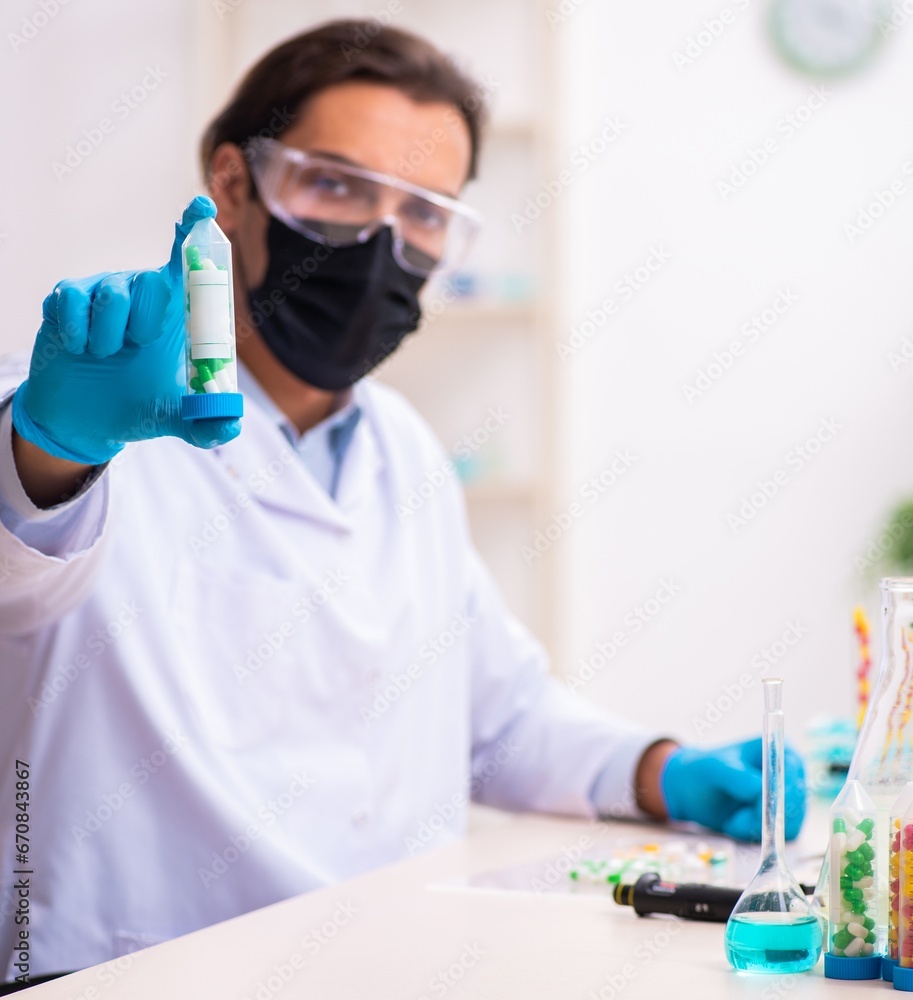 Young male chemist in drug synthesis concept Young male chemist in drug synthesis concept