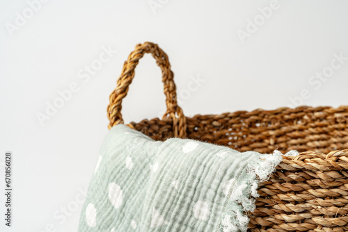 Soft cotton blanket in a straw basket on white background
