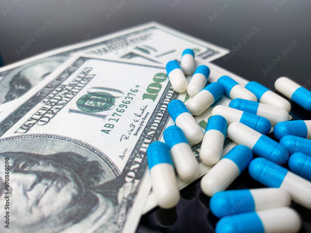 Closeup banknotes and medicine with reflection on a black acrylic board Closeup banknotes and medicine with reflection on a black acrylic board