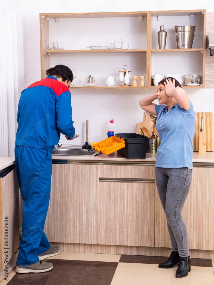 Young male repairman repairing tap Young male repairman repairing tap