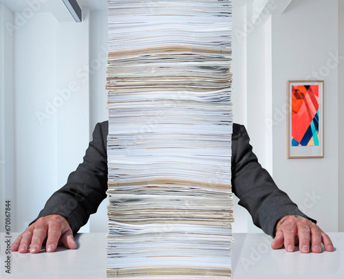 Angestellter hinter einem Berg Papierstabel