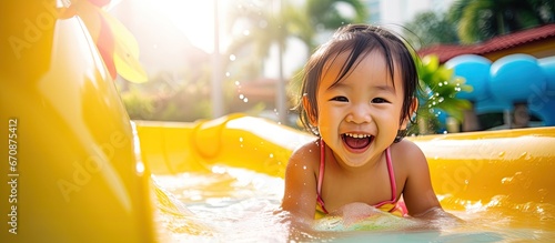 Happy Asian baby girl laughing and playing in the resort pool with her family
