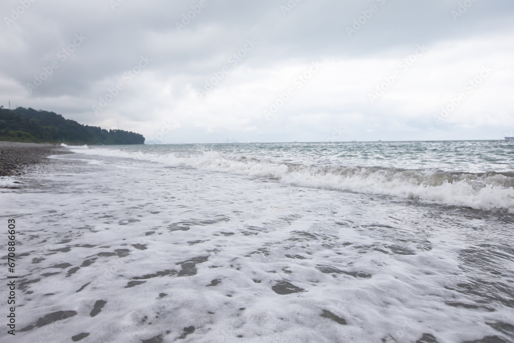 Seascape with a pebble beach and the spreading waves of the Black Sea.