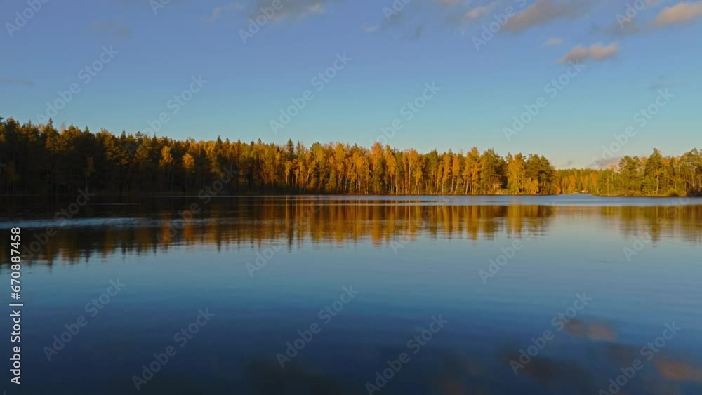 Flying low over a body of water and climbing up to reveal an endless forest and Fiskträsk lake in Sipoonkorpi National Park in Finland. Autumn has turned the leaves yellow, red and brown. Flying low over a body of water and climbing up to reveal an endless forest and Fiskträsk lake in Sipoonkorpi National Park in Finland. Autumn has turned the leaves yellow, red and brown.