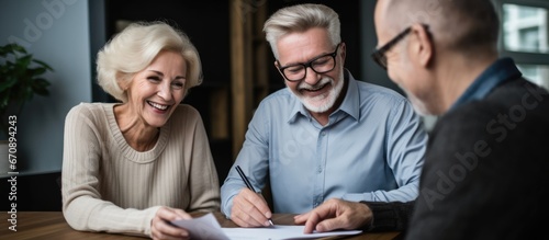 Elderly couple signing papers with social worker photo