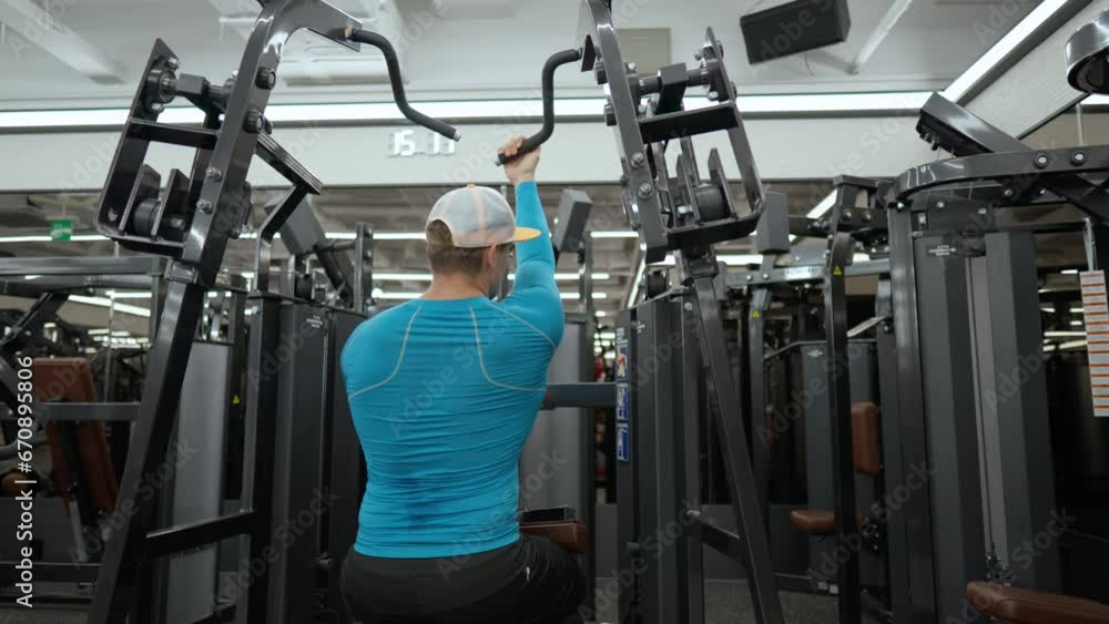 Muscular ManTraining Back Muscles at Lat Pulldown Machine at Modern Gym Muscular ManTraining Back Muscles at Lat Pulldown Machine at Modern Gym