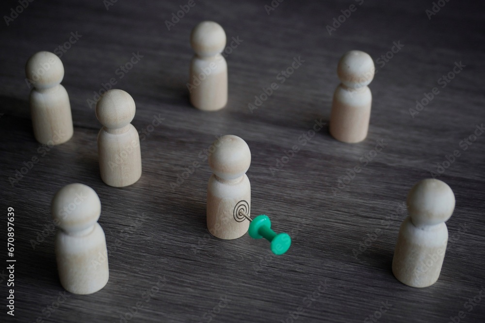 Wooden dolls and pushpin. Target customer, target market and potential client concept. Wooden dolls and pushpin. Target customer, target market and potential client concept.