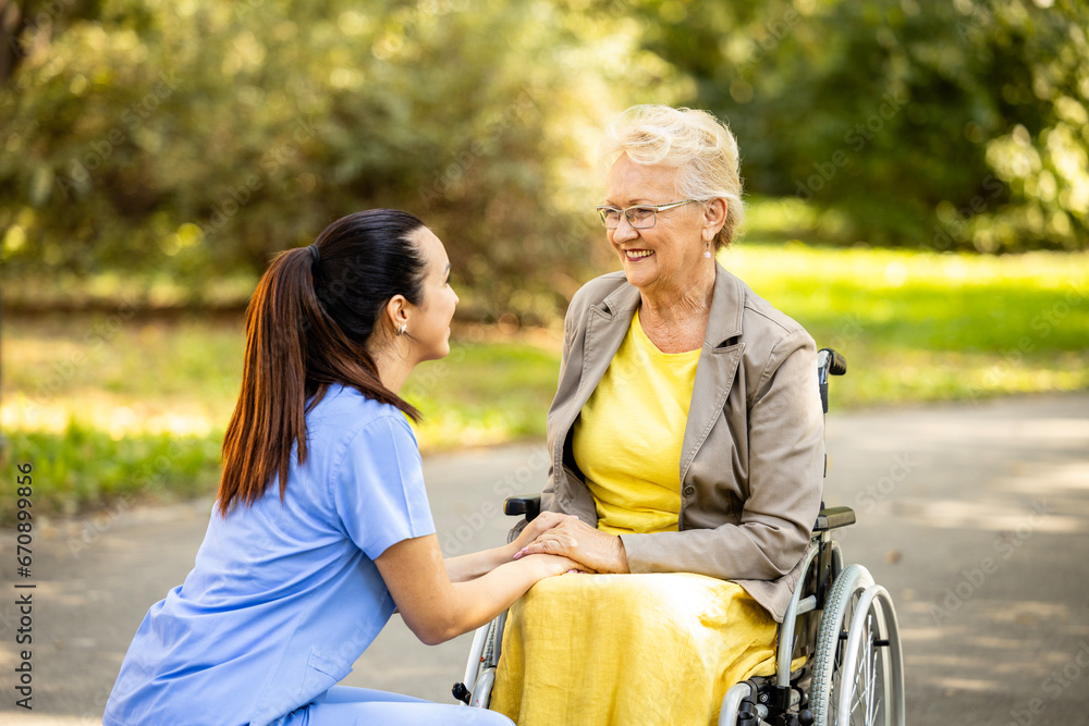 Nursing assistant taking care of elderly woman in wheelchair. Nursing assistant taking care of elderly woman in wheelchair.