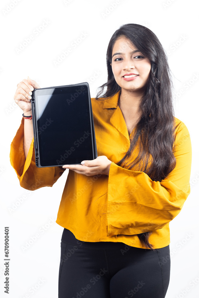 Young Indian, asian business woman, collage girl, student, confident female entrepreneur wearing professional outfit dress pointing at tablet for advertisement isolated on white background Young Indian, asian business woman, collage girl, student, confident female entrepreneur wearing professional outfit dress pointing at tablet for advertisement isolated on white background