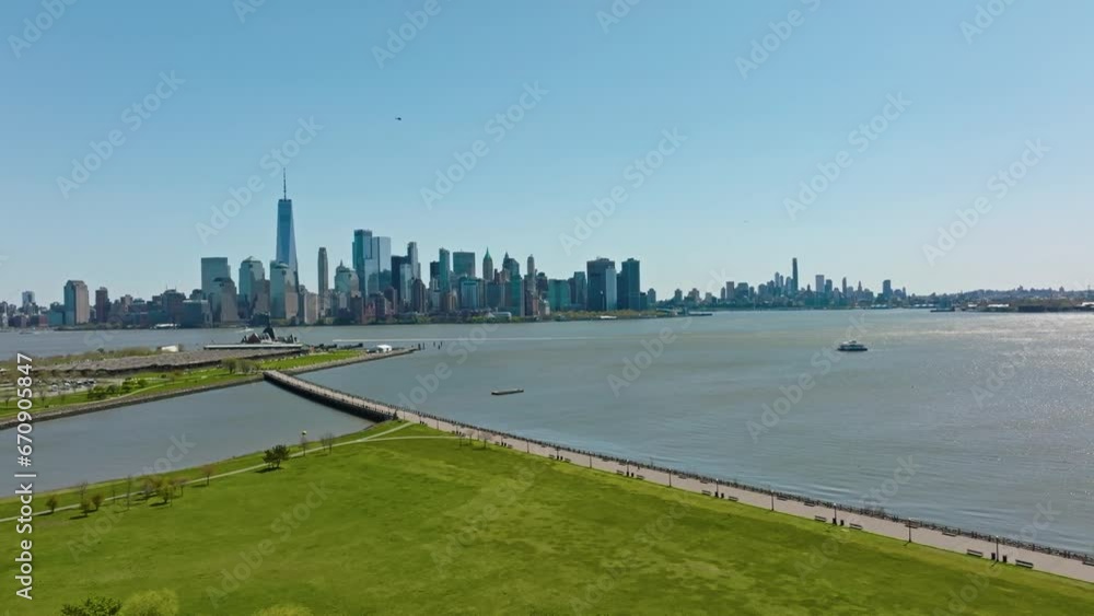 Drone approaching shot of Liberty State Park with Manhattan with skyline against blue sky in summer Drone approaching shot of Liberty State Park with Manhattan with skyline against blue sky in summer