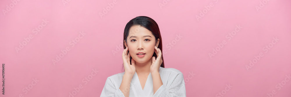 Banner of an beautiful young woman feeling her skin against a pink background. Banner of an beautiful young woman feeling her skin against a pink background.