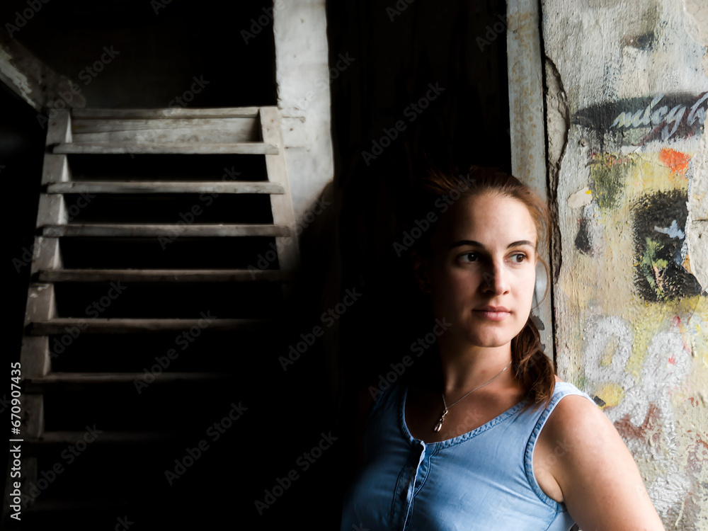 Fototapeta premium Young woman in a ruined house