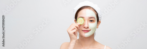 naked young woman with clay mask and cucumbers on face isolated on wide banner