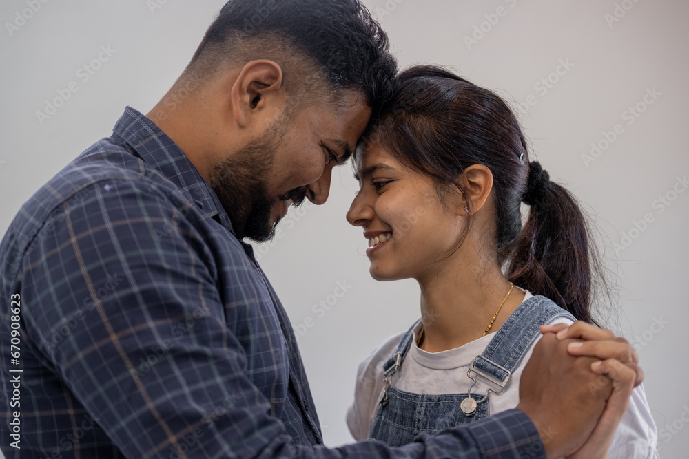 Happy Indian young couple adult caucasian man woman husband and wife dancing at home house