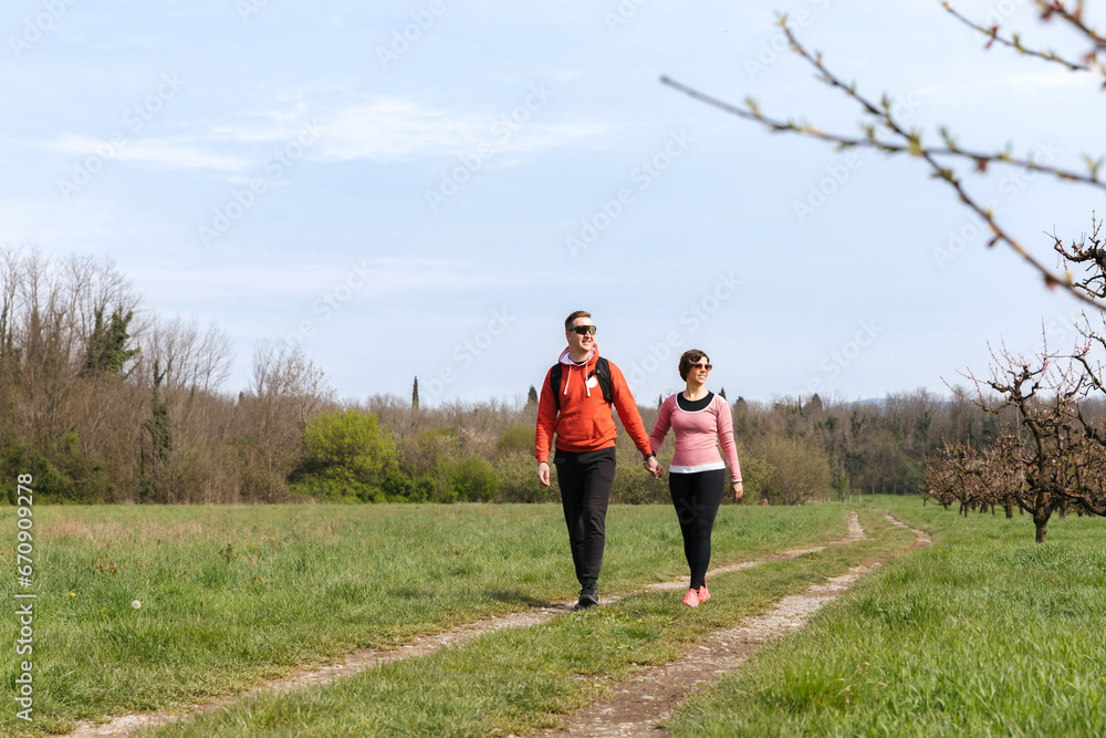 Couple on the morning walk through the orchard Couple on the morning walk through the orchard