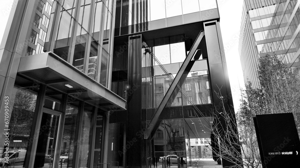 Naklejka premium Combination of metal and glass wall material. Steel facade on columns. Abstract modern architecture. High-tech minimalist office building. Black and white.