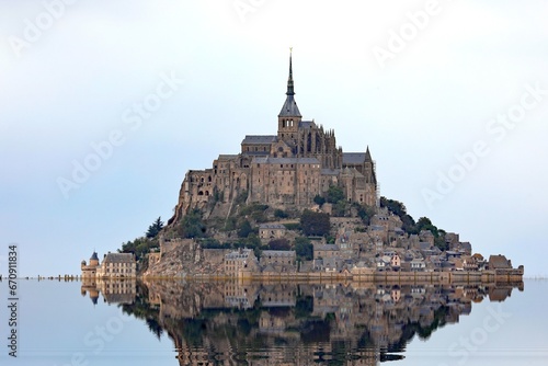 Reflected on the water at high tide of the ancient abbey of Mont Saint Michel in Normandy in France photo