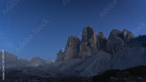 Blue hour and first stars appearing above massive rock mountains Tre Cime, Dolomites, Italy