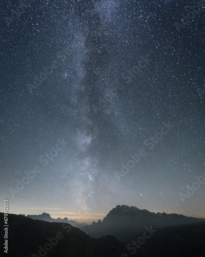 Vertical shot of starry sky and milky way above sharp mountains, Dolomites, Italy