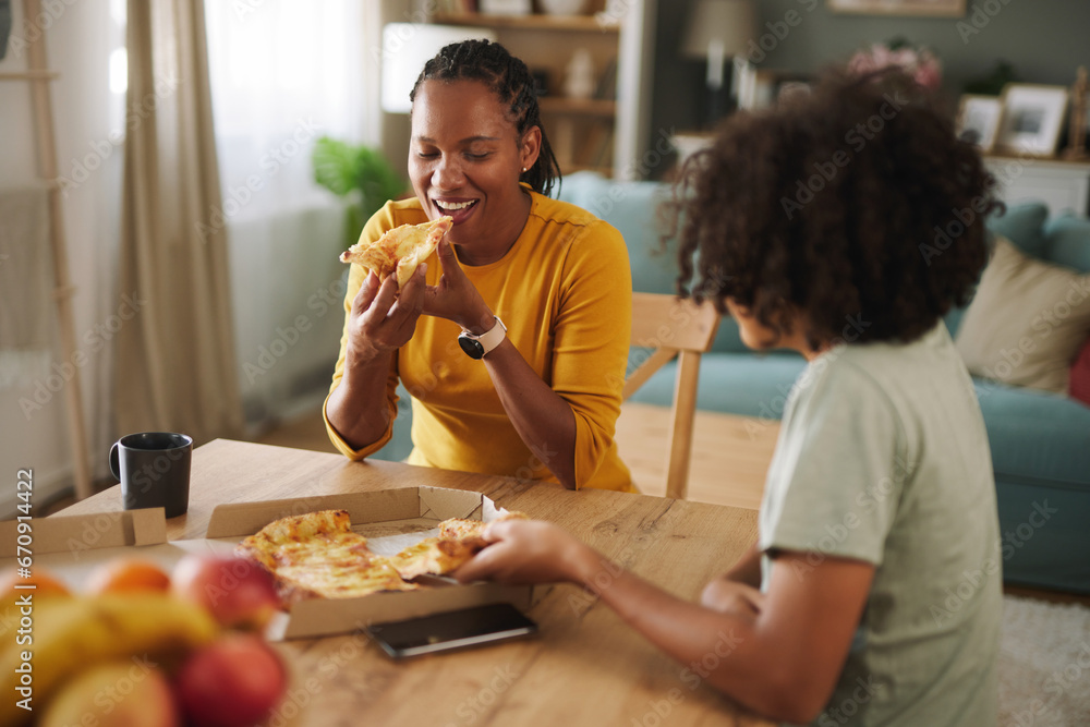 Mother and teenage son having pizza at home Mother and teenage son having pizza at home