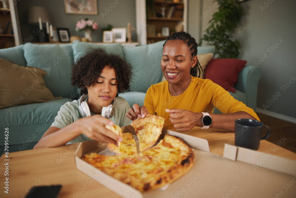 Mother and teenage son having pizza at home