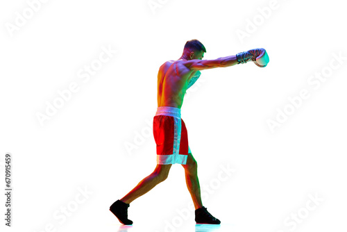 Side view. Energetic professional male boxer, mixed martial art fighter workout against white background in mixed neon filter, light.