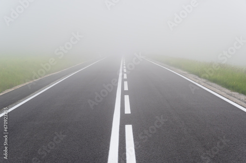 Fototapeta Naklejka Na Ścianę i Meble -  Asphalt road in the heavy fog with clear road markings, Pieniny mountains, Poland