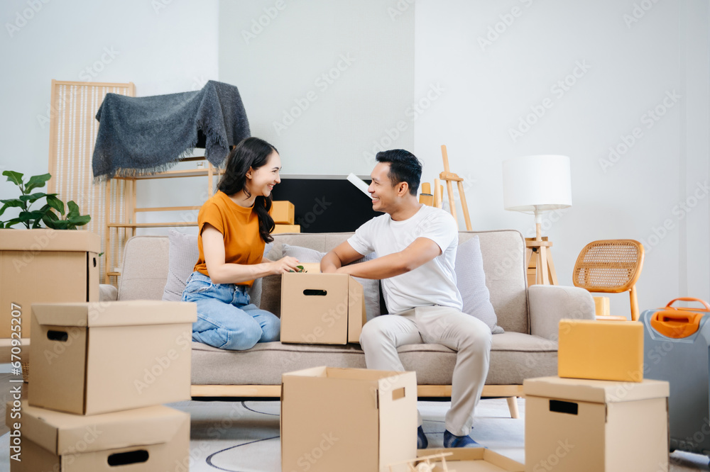 Asian young attractive couple man and woman use tablet and smartphone online shopping furniture decorate house with carton package move in new house. Young married asian moving home. . Asian young attractive couple man and woman use tablet and smartphone online shopping furniture decorate house with carton package move in new house. Young married asian moving home. .