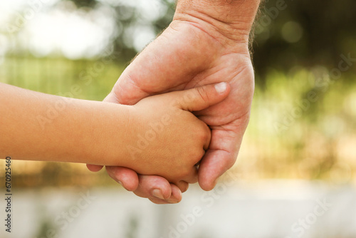 the parent holds the hand of a small child © Kostia