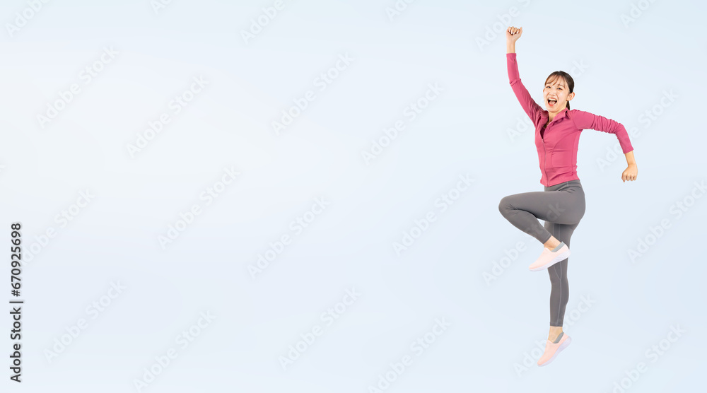 ジャンプするスポーツウェアを着た女性（切り抜き背景透過PNGも販売しております。作成者リンクから「PNG」で検索してください）