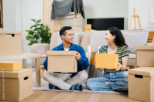 Happy asian young attractive couple man and woman with big boxes moving into a new house, new apartment for couple the new home, Moving house.