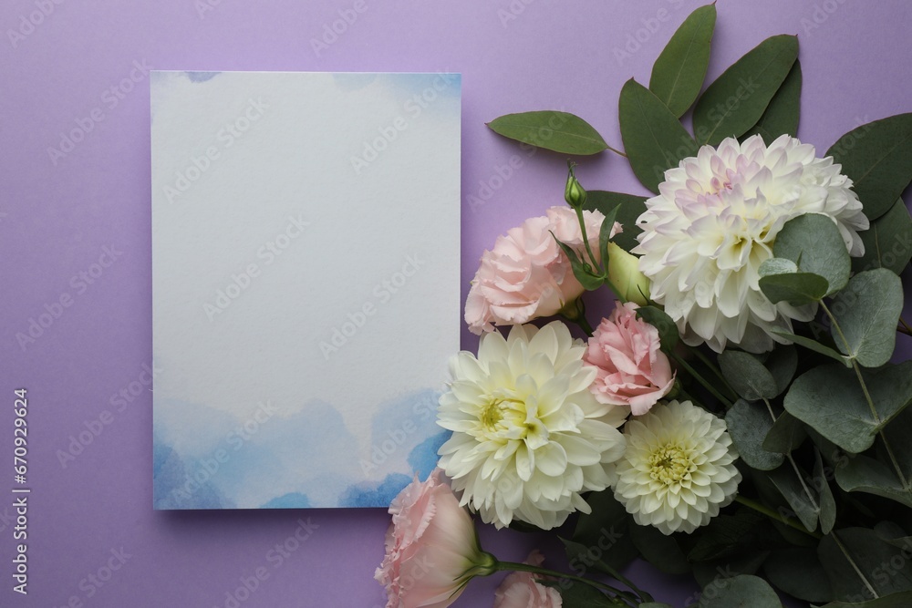 Blank invitation card and beautiful flowers on violet background, flat lay. Space for text