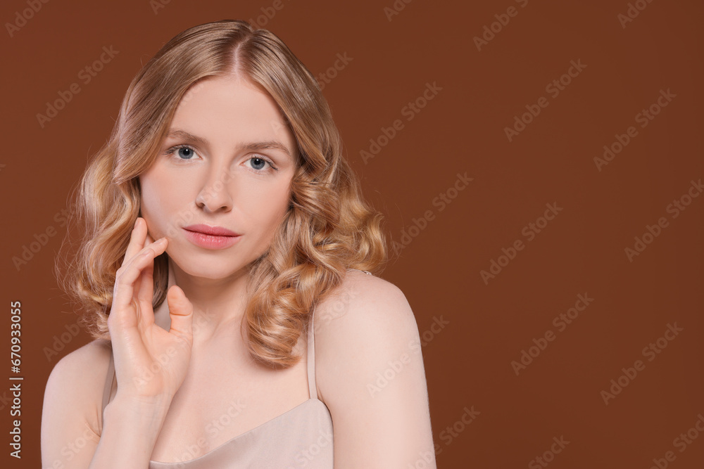 Obraz premium Portrait of beautiful woman with blonde hair on brown background. Space for text
