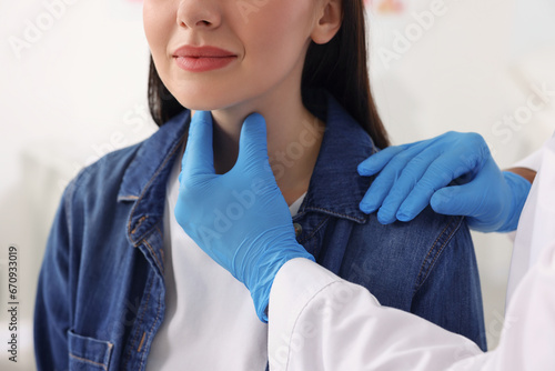 Endocrinologist examining thyroid gland of patient at hospital, closeup photo