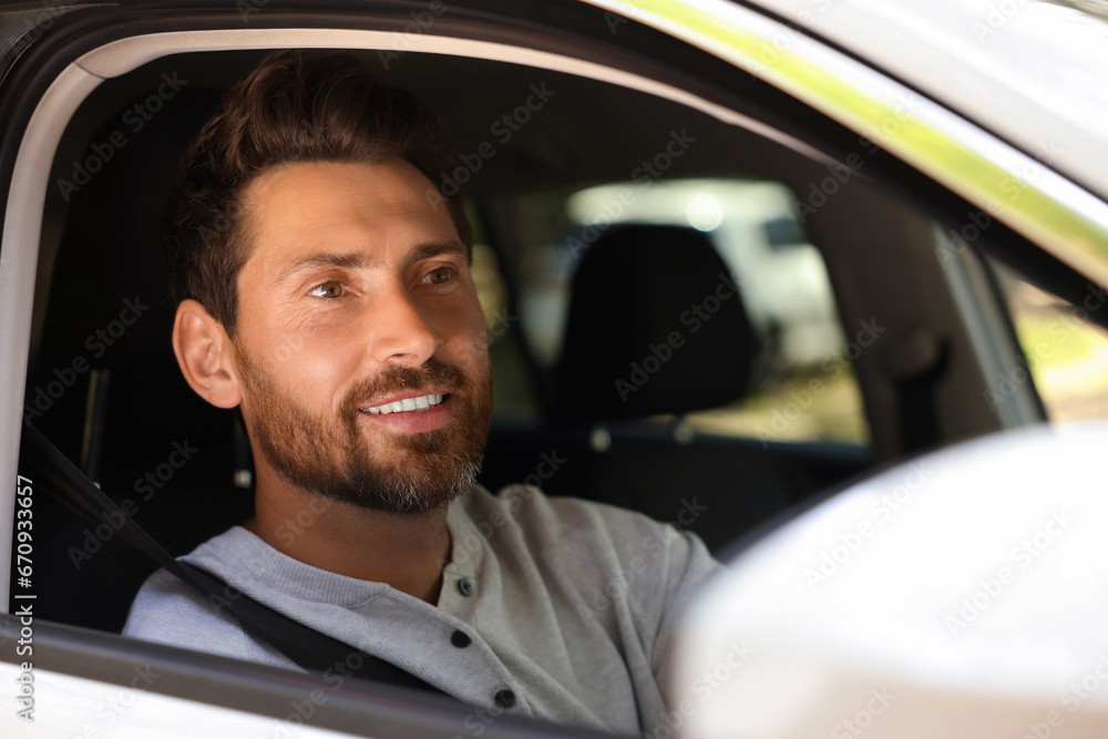 Happy bearded man sitting in car, view from outside. Enjoying trip Happy bearded man sitting in car, view from outside. Enjoying trip