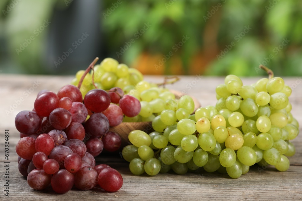 Different fresh ripe grapes on wooden table