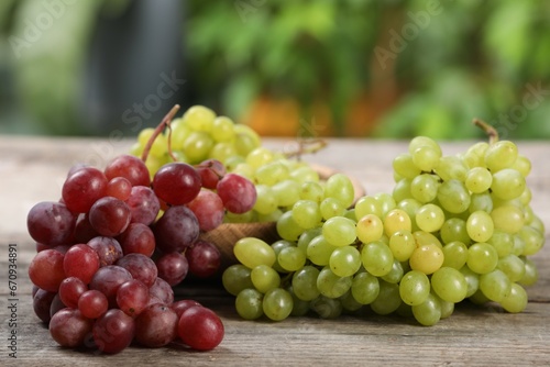 Different fresh ripe grapes on wooden table
