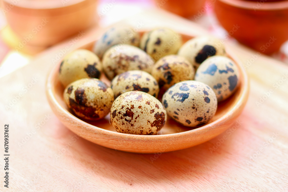 Quail eggs in a wooden bowl on a wooden background. Selective focus. Quail eggs in a wooden bowl on a wooden background. Selective focus.