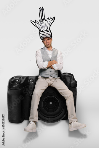 Portrait of uninspired unhappy male photographer with broken lightbulb idea