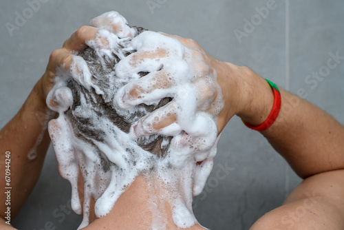 Mężczyzna myje wlosy pod prysznicem