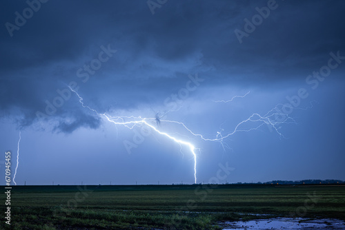 Exceptionally bright lightning strikes earth during a severe nighttime thunderstorm