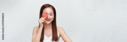 Attractive asian woman covering eyes with small red hearts, panorama © makistock