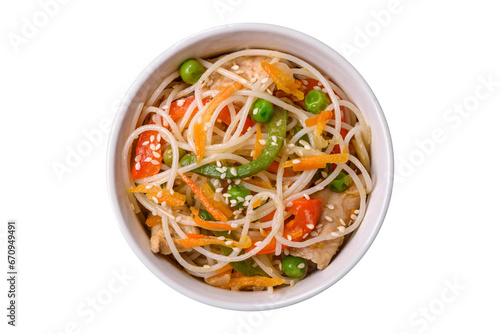 Tasty dish of Asian cuisine with rice noodles, chicken, asparagus, pepper, sesame seeds