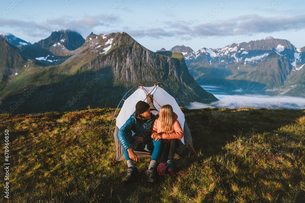 Couple friends traveling together with camping tent gear romantic vacations man and woman hiking adventure outdoor family healthy lifestyle explore mountains of Norway