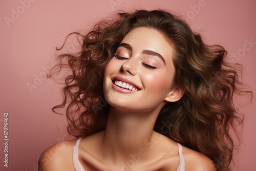 Young girl with perfect skin on her face on a pink background  a happy girl enjoys the freshness of her skin after skin care procedures