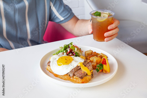 Breakfast egg and roast beef open faced sandwich served at a cafe restaurant.