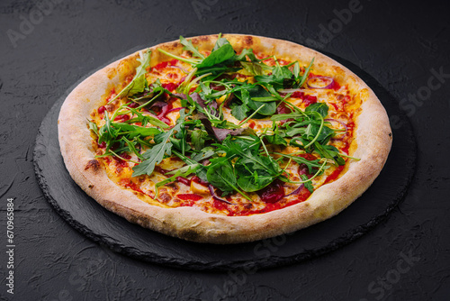 pizza with arugula on black board