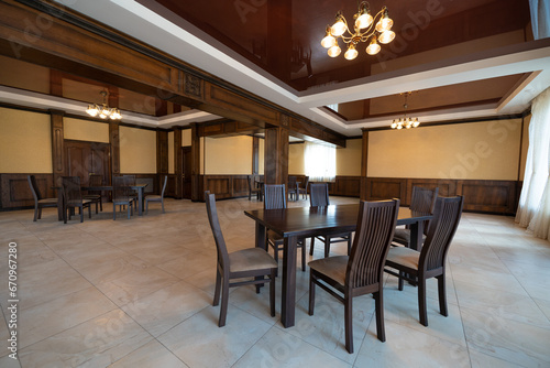 spacious interior of modern empty large restaurant with tables and chairs.