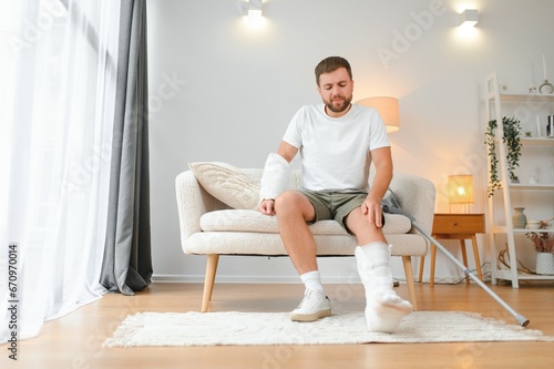 Fotografie Recovery after physical injury in accident at home: Sad unlucky young man with b